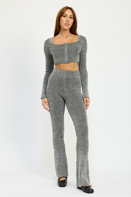 A person wearing HIGH WAIST RIBED PANTS and a grey knit long-sleeve crop top, made from 60% cotton, size small, standing against a plain background.