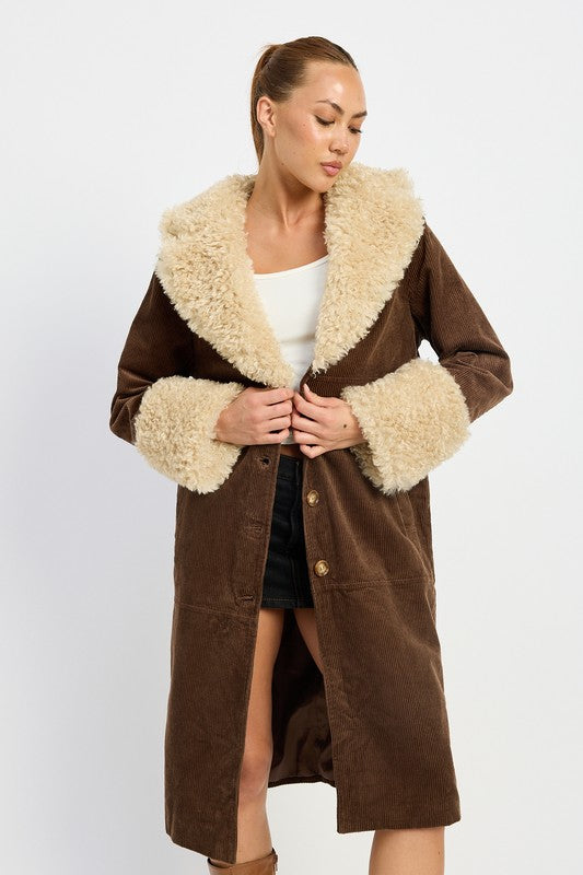 A woman in a blue top, jeans, and sneakers, wearing the FAUX FUR MID TRENCH COAT in beige with white fur trim on the collar and cuffs, size small, stands against a plain background.