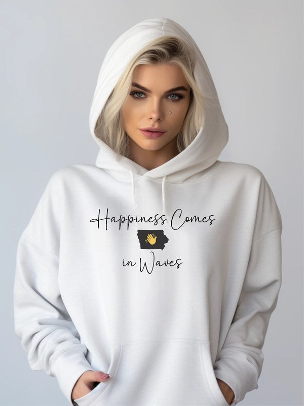 A person wearing a light gray "Happiness Comes in Waves Hoodie Sweatshirt" holds a takeaway coffee cup. This unisex sweatshirt, made from cozy cotton/poly fleece, epitomizes comfort and joy on the go.