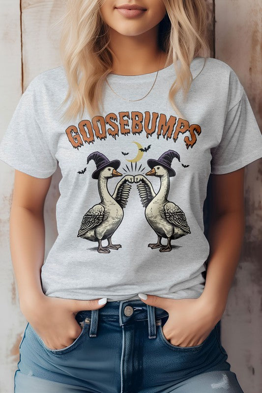 A woman wearing the Vintage Halloween Farm Goose, Graphic Tee, which is eco-friendly and showcases two geese in top hats under the text "Goosebumps." Its unisex fit ensures it's ideal for anyone who appreciates a touch of Vintage Halloween charm.