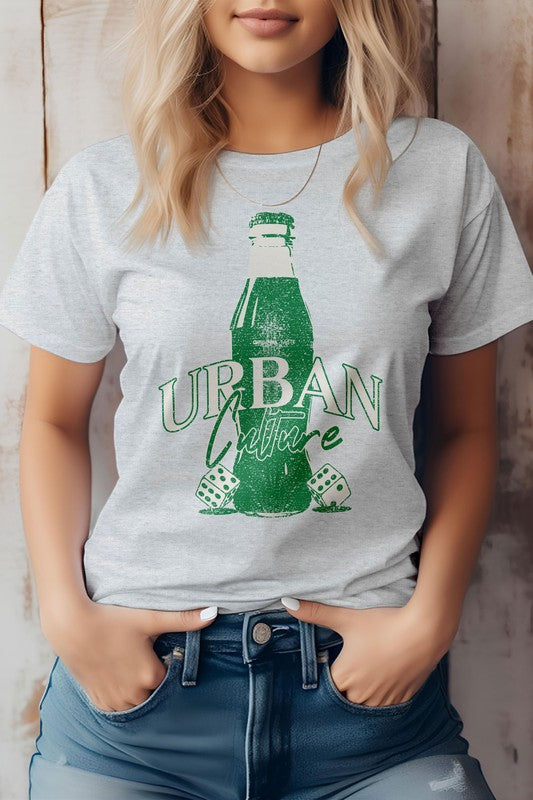 A person wearing the Urban Culture Street Graphic Tee in light green, featuring a vintage Coca-Cola bottle design, stands with hands in jeans pockets.