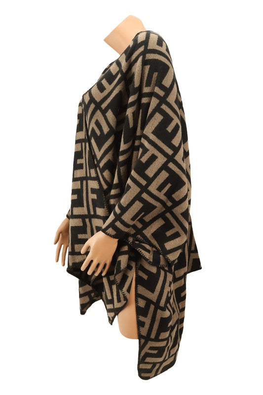 The Greek Pattern Poncho is a black and white poncho featuring an all-over geometric Greek pattern and an asymmetrical hem.