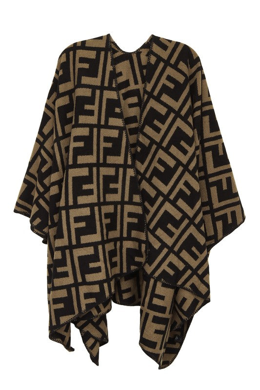 The Greek Pattern Poncho is a black and white poncho featuring an all-over geometric Greek pattern and an asymmetrical hem.