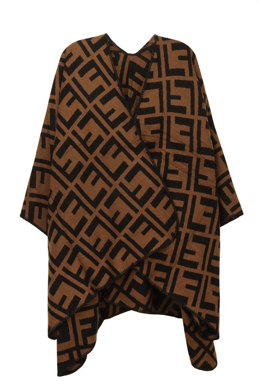 The Greek Pattern Poncho is a black and white poncho featuring an all-over geometric Greek pattern and an asymmetrical hem.