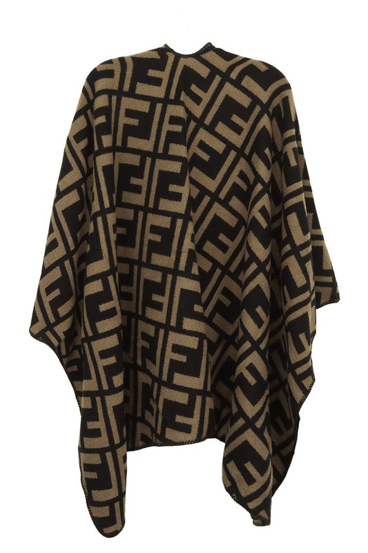 The Greek Pattern Poncho is a black and white poncho featuring an all-over geometric Greek pattern and an asymmetrical hem.