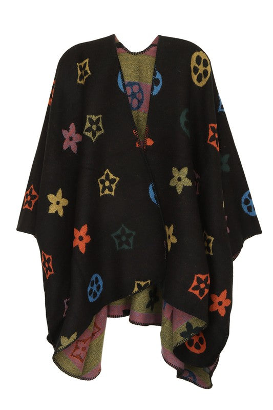 A black poncho featuring a colorful floral and geometric pattern. Styled open in the front with a draped design, this piece offers the elegance of the Multi Color and Geometric Pattern Poncho.