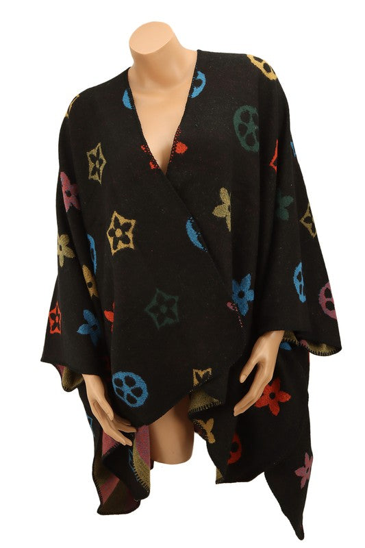 A black poncho featuring a colorful floral and geometric pattern. Styled open in the front with a draped design, this piece offers the elegance of the Multi Color and Geometric Pattern Poncho.