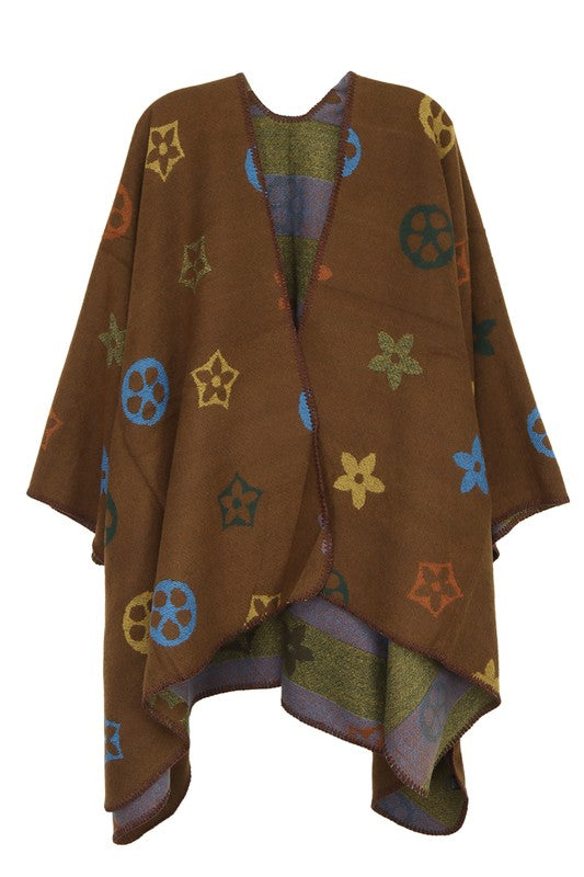 A black poncho featuring a colorful floral and geometric pattern. Styled open in the front with a draped design, this piece offers the elegance of the Multi Color and Geometric Pattern Poncho.