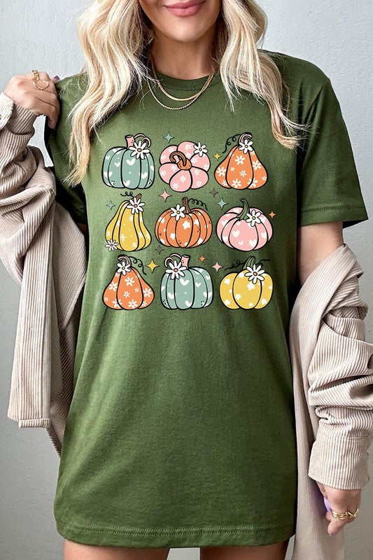 Person wearing a white Pumpkins & Daisies Retro Fall Graphic Tee featuring colorful, cartoonish pumpkins in various shapes and designs, beneath an open jean jacket.