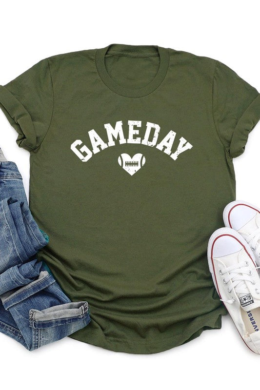 A red Game Day Football Heart Graphic Tee featuring the word "GAMEDAY" with a football inside a heart graphic below it, laid on a white surface paired with blue jeans, a striped scarf, and tan ankle boots. Ideal for Family Group Uniforms on game day!