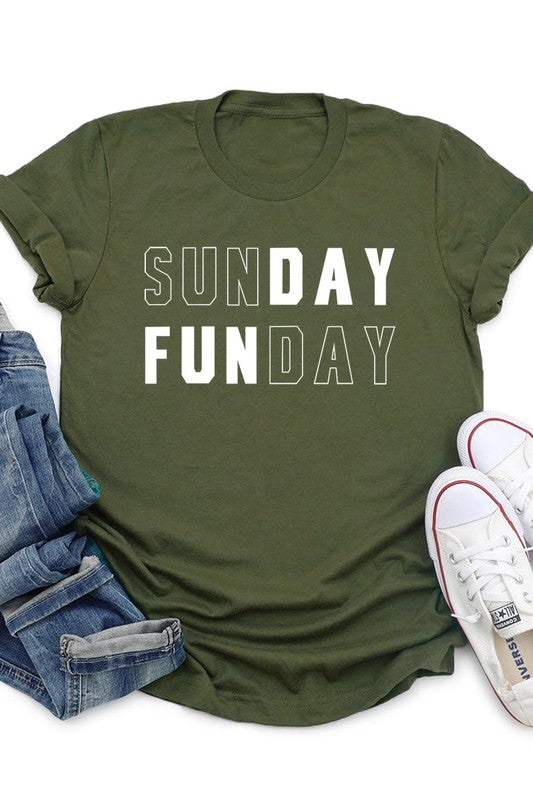 A light pink Sunday Funday Graphic Tee featuring the "SUNDAY FUNDAY" print is hanging on a wooden hanger next to a tan hat and a beige bag filled with flowers. This unisex crew neck short sleeve tee is ideal for family group uniforms.