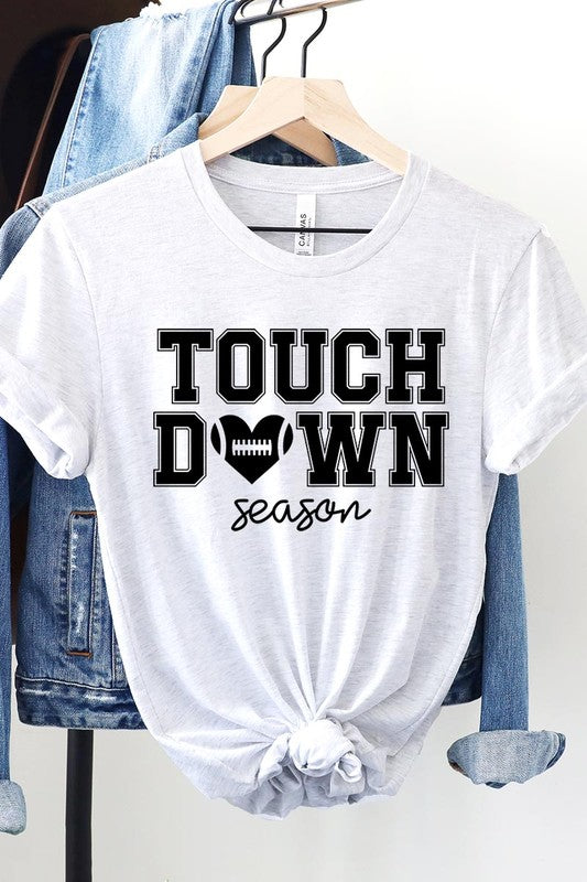 A Touchdown Season Graphic Tee in dark gray with a high-quality direct-to-film printed design, paired with blue jeans and beige ankle boots, laid out flat.