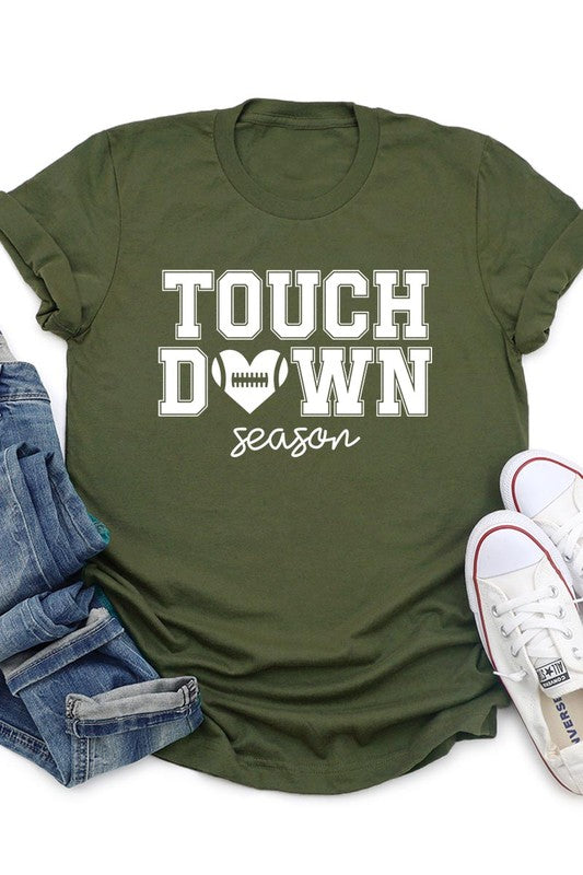 A Touchdown Season Graphic Tee in dark gray with a high-quality direct-to-film printed design, paired with blue jeans and beige ankle boots, laid out flat.