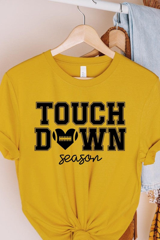 A Touchdown Season Graphic Tee in dark gray with a high-quality direct-to-film printed design, paired with blue jeans and beige ankle boots, laid out flat.