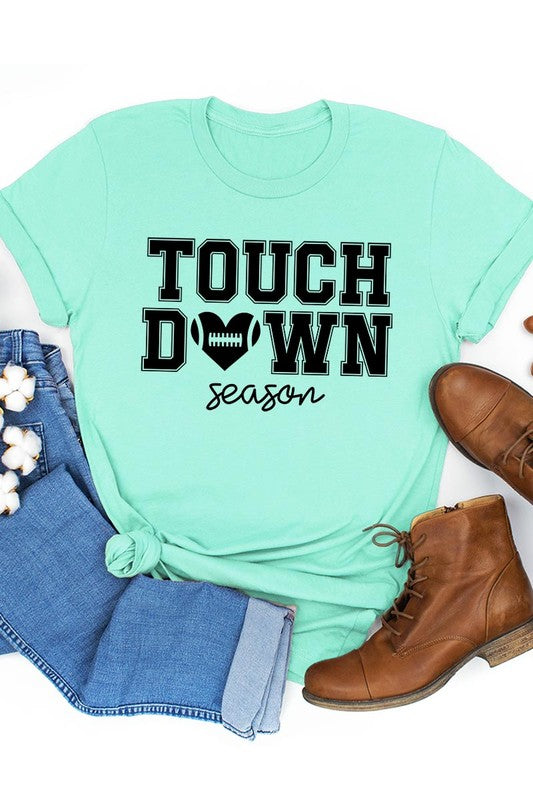 A Touchdown Season Graphic Tee in dark gray with a high-quality direct-to-film printed design, paired with blue jeans and beige ankle boots, laid out flat.