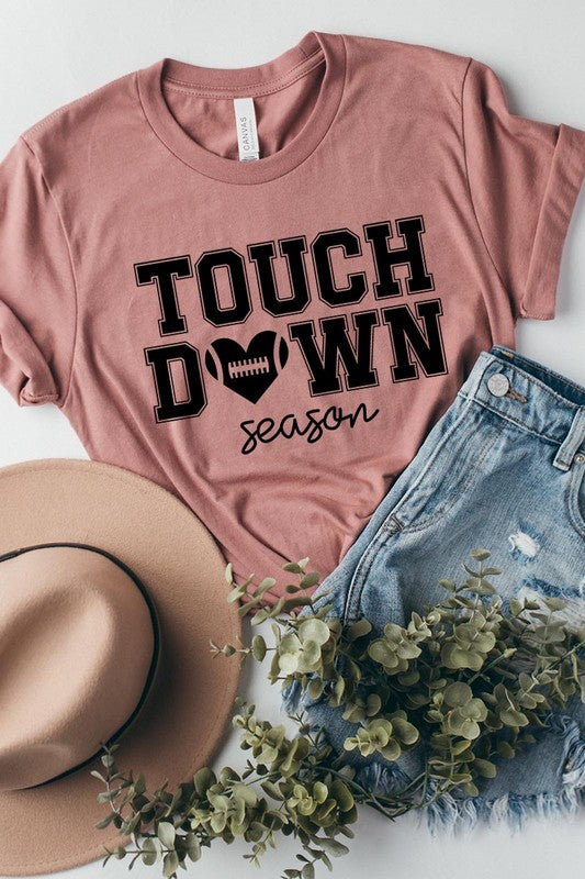 A Touchdown Season Graphic Tee in dark gray with a high-quality direct-to-film printed design, paired with blue jeans and beige ankle boots, laid out flat.