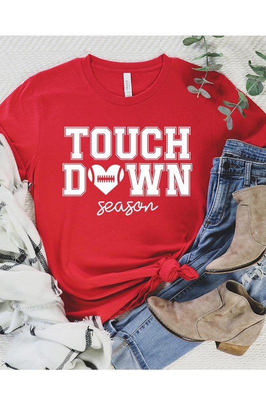 A Touchdown Season Graphic Tee in dark gray with a high-quality direct-to-film printed design, paired with blue jeans and beige ankle boots, laid out flat.