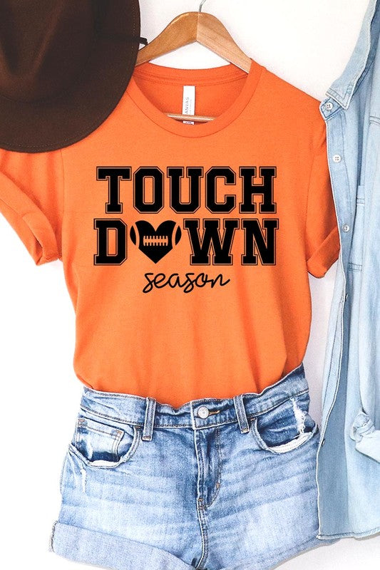 A Touchdown Season Graphic Tee in dark gray with a high-quality direct-to-film printed design, paired with blue jeans and beige ankle boots, laid out flat.