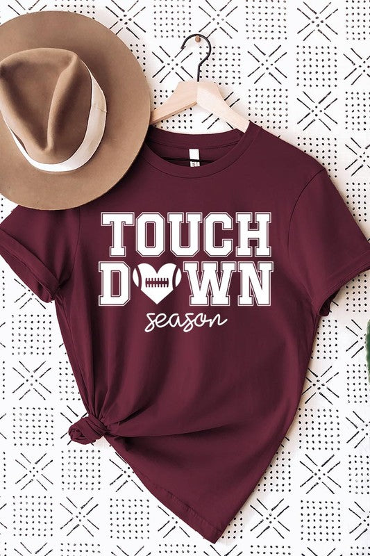 A Touchdown Season Graphic Tee in dark gray with a high-quality direct-to-film printed design, paired with blue jeans and beige ankle boots, laid out flat.