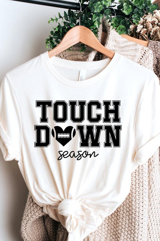 A Touchdown Season Graphic Tee in dark gray with a high-quality direct-to-film printed design, paired with blue jeans and beige ankle boots, laid out flat.