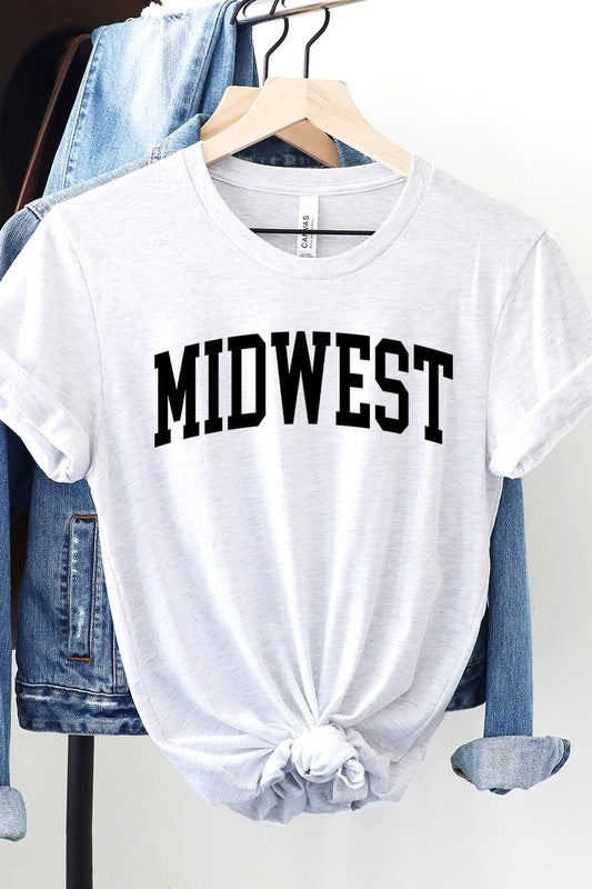 A light pink Unisex Crew Neck Midwest Graphic Tee, featuring rolled sleeves and the word "MIDWEST" printed in bold black letters, hangs on a wooden hanger. This tee makes a perfect addition to your Family Group Uniforms.