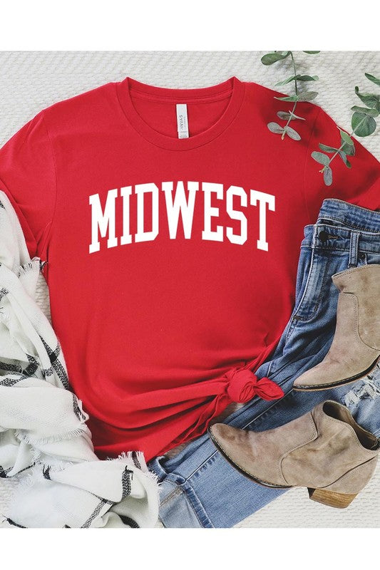 A light pink Unisex Crew Neck Midwest Graphic Tee, featuring rolled sleeves and the word "MIDWEST" printed in bold black letters, hangs on a wooden hanger. This tee makes a perfect addition to your Family Group Uniforms.