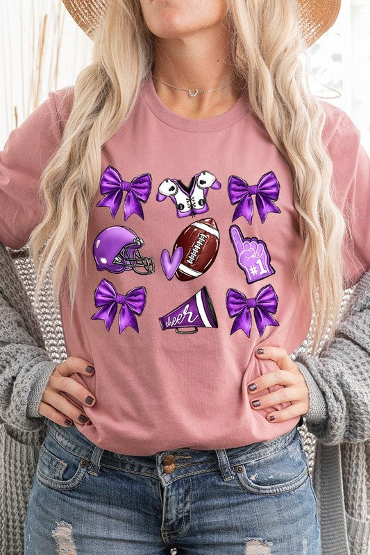 Someone wearing a Purple Coquette Football Graphic Tee, a unisex crew neck pink t-shirt decorated with sports-themed illustrations like a football, helmet, megaphone, foam finger, and cheerleading accessories in purple and white.