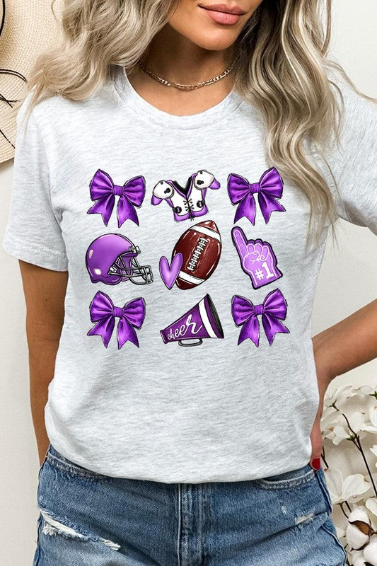 Someone wearing a Purple Coquette Football Graphic Tee, a unisex crew neck pink t-shirt decorated with sports-themed illustrations like a football, helmet, megaphone, foam finger, and cheerleading accessories in purple and white.