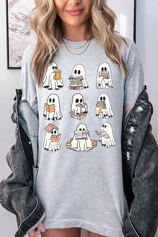 A person wears a brown shirt featuring illustrations of cute ghosts reading, holding, and interacting with books. This Funny Ghost Book Nerd Graphic Tee is paired with a partially worn denim jacket, showcasing its high-quality printed design.