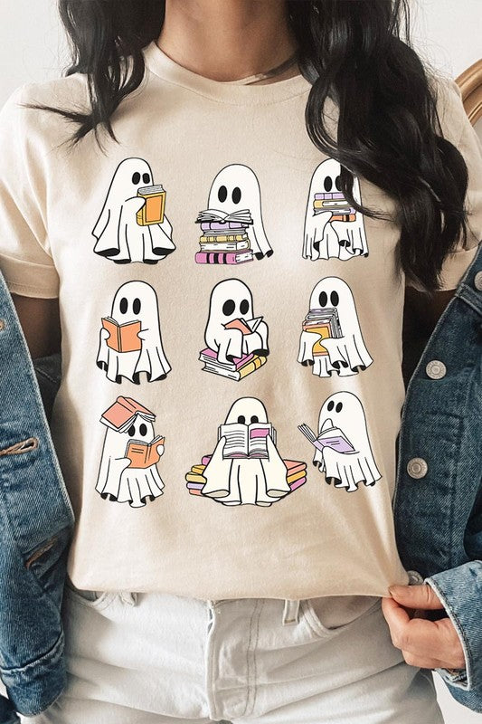 A person wears a brown shirt featuring illustrations of cute ghosts reading, holding, and interacting with books. This Funny Ghost Book Nerd Graphic Tee is paired with a partially worn denim jacket, showcasing its high-quality printed design.