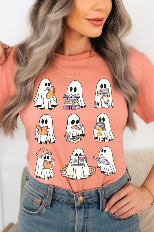 A person wears a brown shirt featuring illustrations of cute ghosts reading, holding, and interacting with books. This Funny Ghost Book Nerd Graphic Tee is paired with a partially worn denim jacket, showcasing its high-quality printed design.