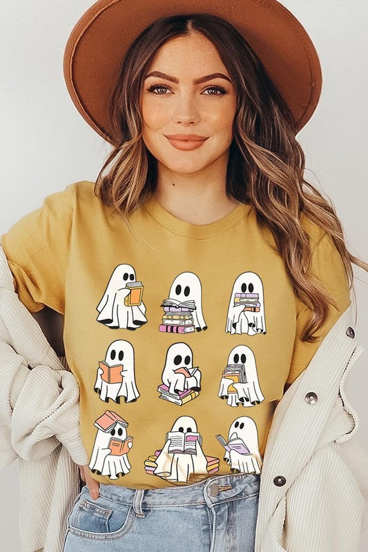 A person wears a brown shirt featuring illustrations of cute ghosts reading, holding, and interacting with books. This Funny Ghost Book Nerd Graphic Tee is paired with a partially worn denim jacket, showcasing its high-quality printed design.