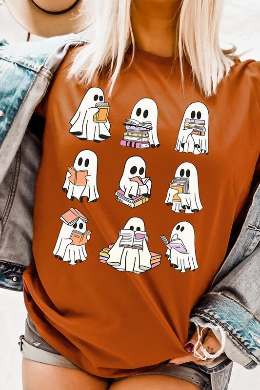 A person wears a brown shirt featuring illustrations of cute ghosts reading, holding, and interacting with books. This Funny Ghost Book Nerd Graphic Tee is paired with a partially worn denim jacket, showcasing its high-quality printed design.