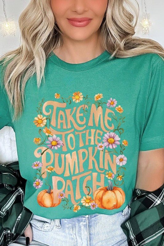 Person wearing a Take Me To The Pumpkin Patch Graphic Tee, which is a navy blue unisex crew neck t-shirt featuring the words "Take me to the pumpkin patch" surrounded by flowers and pumpkins.