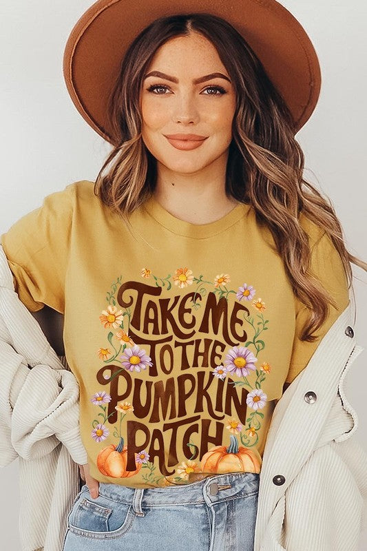 Person wearing a Take Me To The Pumpkin Patch Graphic Tee, which is a navy blue unisex crew neck t-shirt featuring the words "Take me to the pumpkin patch" surrounded by flowers and pumpkins.