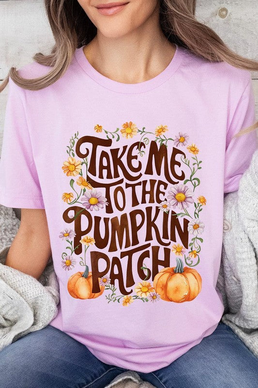 Person wearing a Take Me To The Pumpkin Patch Graphic Tee, which is a navy blue unisex crew neck t-shirt featuring the words "Take me to the pumpkin patch" surrounded by flowers and pumpkins.