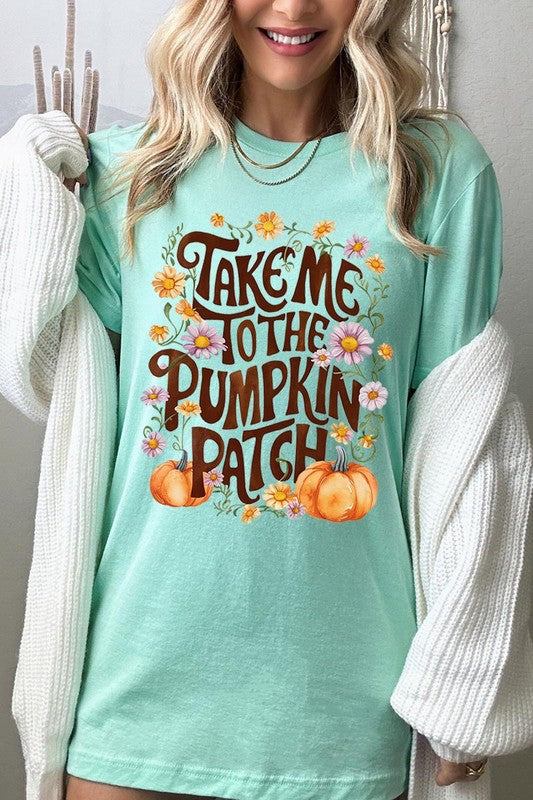 Person wearing a Take Me To The Pumpkin Patch Graphic Tee, which is a navy blue unisex crew neck t-shirt featuring the words "Take me to the pumpkin patch" surrounded by flowers and pumpkins.