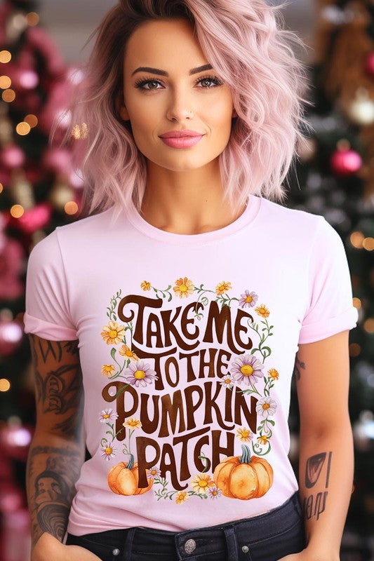 Person wearing a Take Me To The Pumpkin Patch Graphic Tee, which is a navy blue unisex crew neck t-shirt featuring the words "Take me to the pumpkin patch" surrounded by flowers and pumpkins.