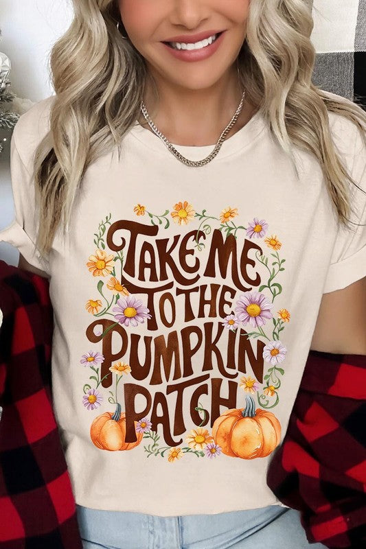 Person wearing a Take Me To The Pumpkin Patch Graphic Tee, which is a navy blue unisex crew neck t-shirt featuring the words "Take me to the pumpkin patch" surrounded by flowers and pumpkins.