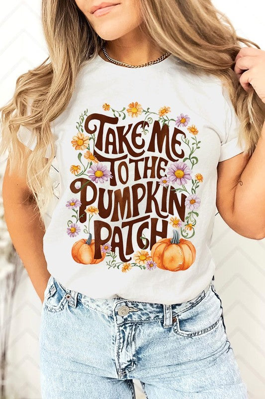 Person wearing a Take Me To The Pumpkin Patch Graphic Tee, which is a navy blue unisex crew neck t-shirt featuring the words "Take me to the pumpkin patch" surrounded by flowers and pumpkins.