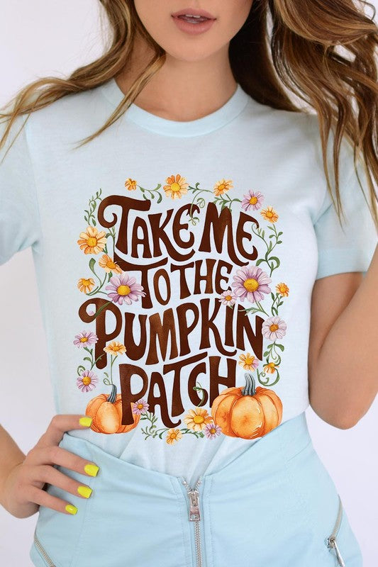 Person wearing a Take Me To The Pumpkin Patch Graphic Tee, which is a navy blue unisex crew neck t-shirt featuring the words "Take me to the pumpkin patch" surrounded by flowers and pumpkins.