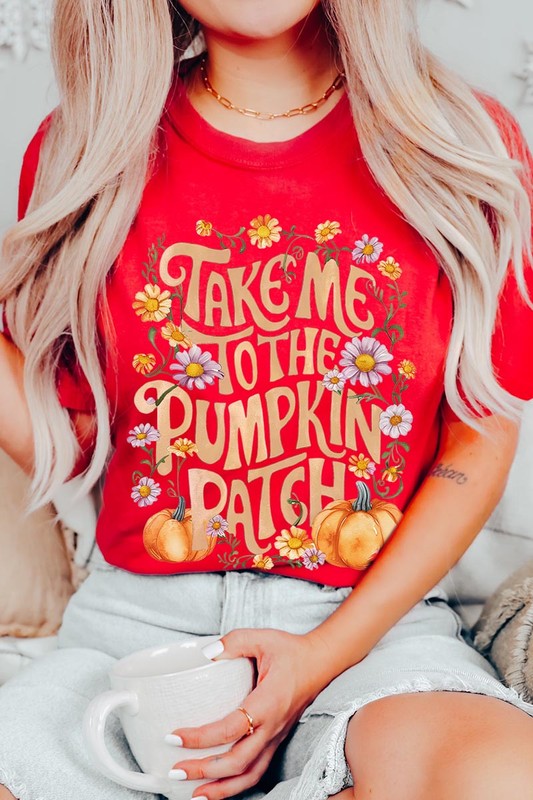 Person wearing a Take Me To The Pumpkin Patch Graphic Tee, which is a navy blue unisex crew neck t-shirt featuring the words "Take me to the pumpkin patch" surrounded by flowers and pumpkins.