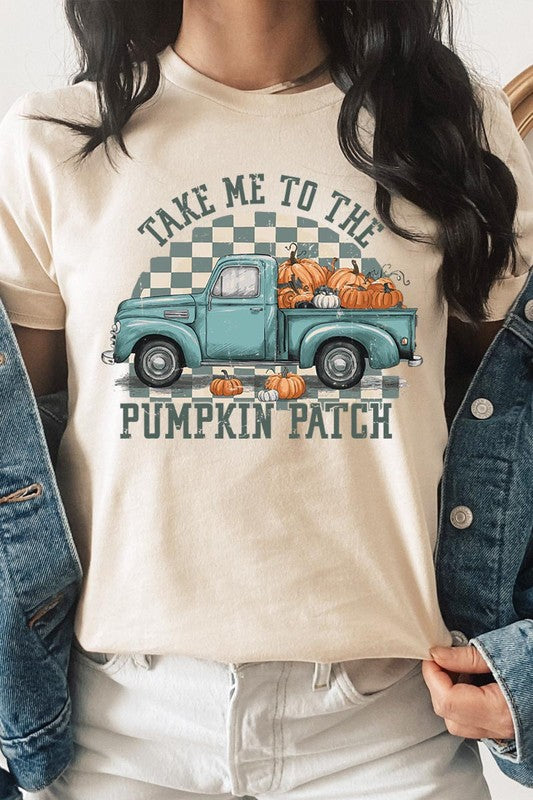 A woman wearing the "Take Me To The Pumpkin Patch Graphic Tee" featuring an illustration of a teal truck carrying pumpkins and the text "Take Me to the Pumpkin Patch." She has a green plaid shirt draped over her shoulders, creating a perfect match for Family Group Uniforms.