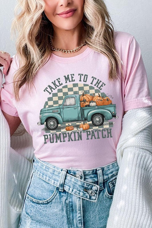 A woman wearing the "Take Me To The Pumpkin Patch Graphic Tee" featuring an illustration of a teal truck carrying pumpkins and the text "Take Me to the Pumpkin Patch." She has a green plaid shirt draped over her shoulders, creating a perfect match for Family Group Uniforms.