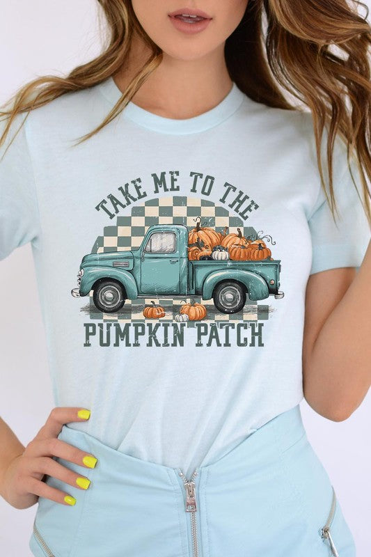 A woman wearing the "Take Me To The Pumpkin Patch Graphic Tee" featuring an illustration of a teal truck carrying pumpkins and the text "Take Me to the Pumpkin Patch." She has a green plaid shirt draped over her shoulders, creating a perfect match for Family Group Uniforms.