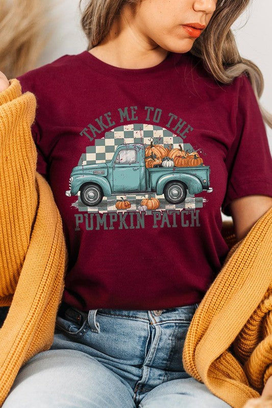 A woman wearing the "Take Me To The Pumpkin Patch Graphic Tee" featuring an illustration of a teal truck carrying pumpkins and the text "Take Me to the Pumpkin Patch." She has a green plaid shirt draped over her shoulders, creating a perfect match for Family Group Uniforms.