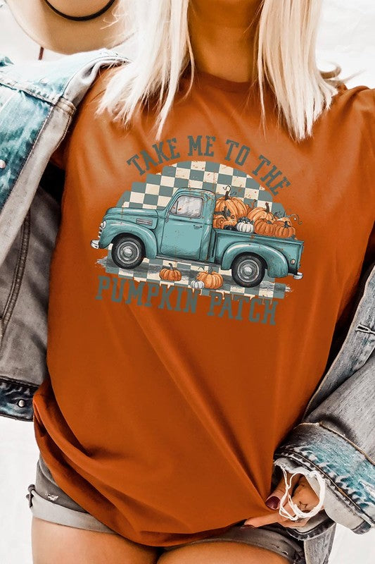 A woman wearing the "Take Me To The Pumpkin Patch Graphic Tee" featuring an illustration of a teal truck carrying pumpkins and the text "Take Me to the Pumpkin Patch." She has a green plaid shirt draped over her shoulders, creating a perfect match for Family Group Uniforms.