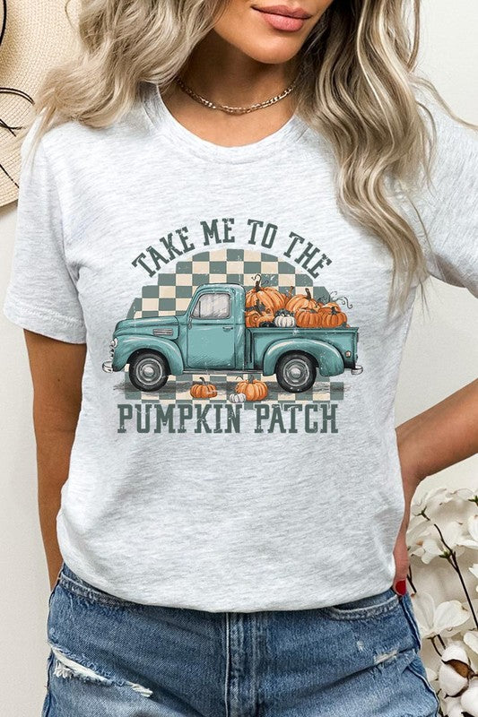 A woman wearing the "Take Me To The Pumpkin Patch Graphic Tee" featuring an illustration of a teal truck carrying pumpkins and the text "Take Me to the Pumpkin Patch." She has a green plaid shirt draped over her shoulders, creating a perfect match for Family Group Uniforms.