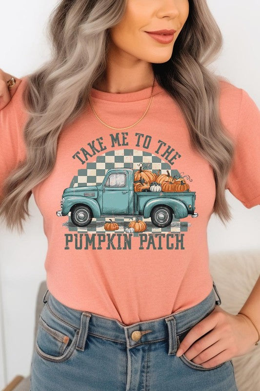 A woman wearing the "Take Me To The Pumpkin Patch Graphic Tee" featuring an illustration of a teal truck carrying pumpkins and the text "Take Me to the Pumpkin Patch." She has a green plaid shirt draped over her shoulders, creating a perfect match for Family Group Uniforms.