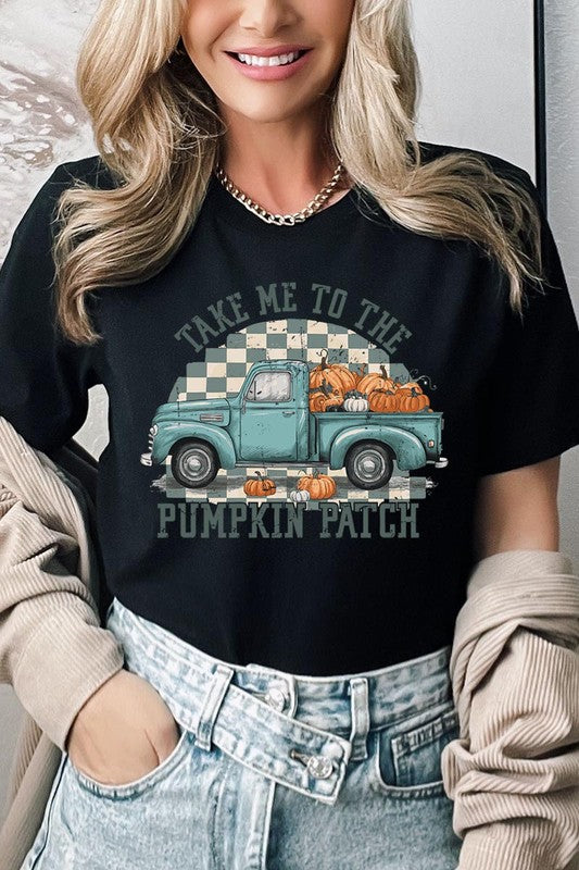 A woman wearing the "Take Me To The Pumpkin Patch Graphic Tee" featuring an illustration of a teal truck carrying pumpkins and the text "Take Me to the Pumpkin Patch." She has a green plaid shirt draped over her shoulders, creating a perfect match for Family Group Uniforms.